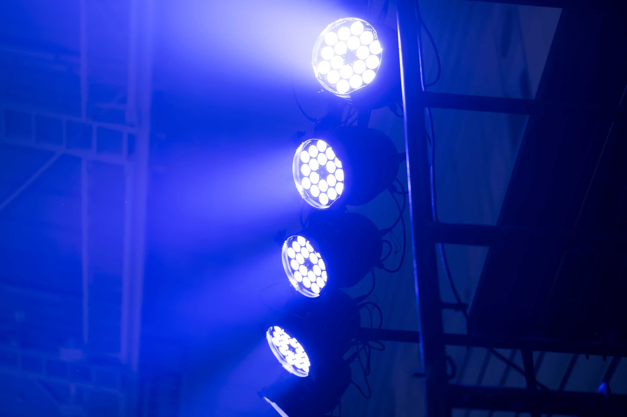 Spots lumineux bleus éclairant une salle de concert
